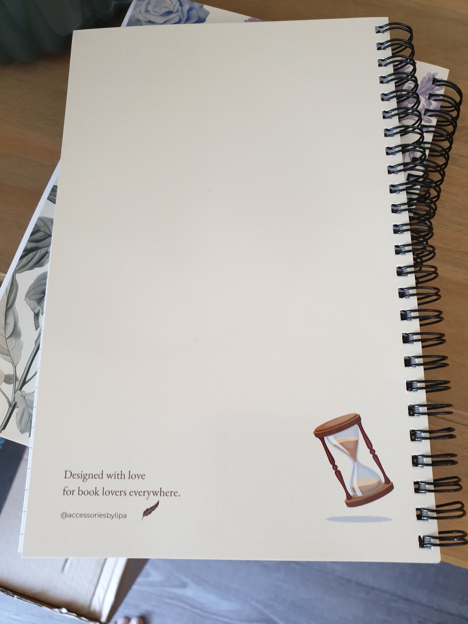Spiral-bound notebook with a plain cover on a wooden surface.